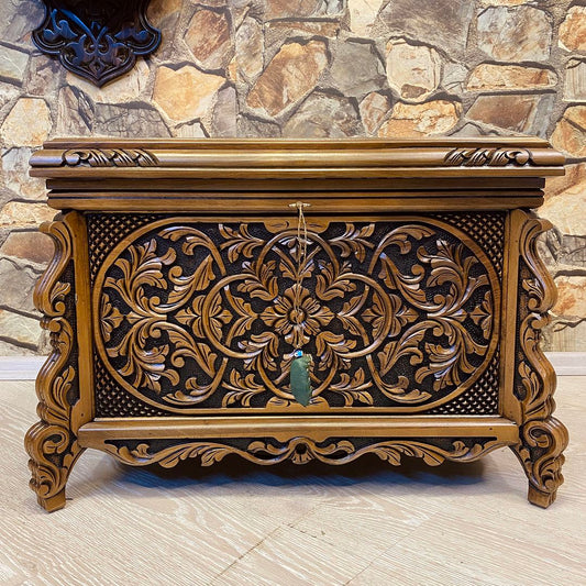 Detailed hand-carved ornamentation on walnut wood chest